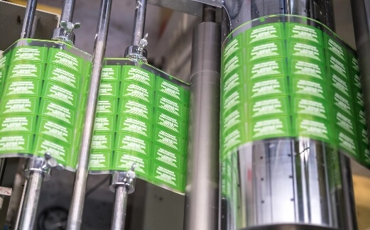 Automated cosmetic labeling and packaging machine for jars, pumps, and bottles