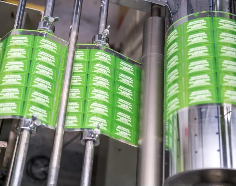 Automated cosmetic labeling and packaging machine for jars, pumps, and bottles